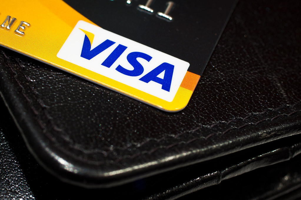 A credit card being held in front of a laptop (purchase protection) (credit card purchase protection)