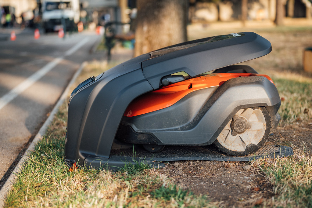 A robot lawn mower operating on grass in a backyard