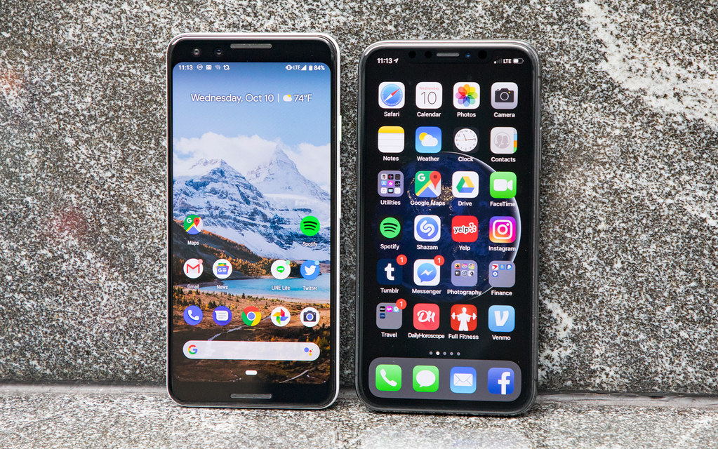Two smartphones placed side by side on a table, representing a comparison between iPhone and Android