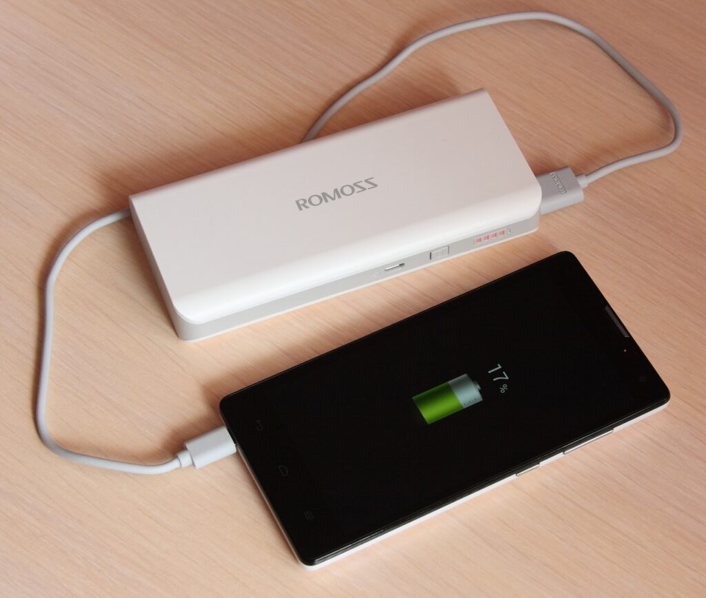 A portable power bank charging a phone, ready for travel