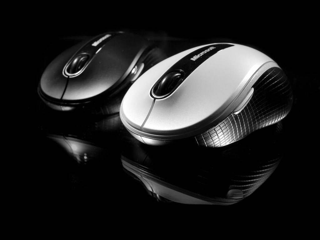 An ergonomic vertical mouse next to a split keyboard on an office desk (ergonomic mouse)
