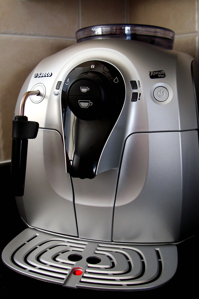 A home espresso machine brewing a shot of espresso on a kitchen counter