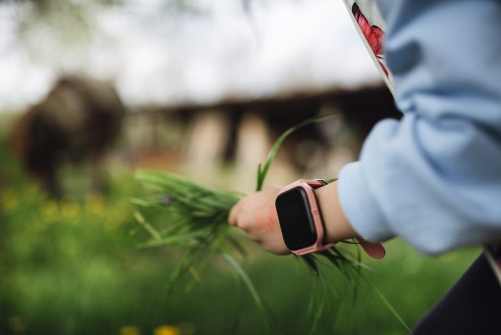 A child's wrist wearing a colorful smartwatch with GPS tracking features (kids smartwatch)