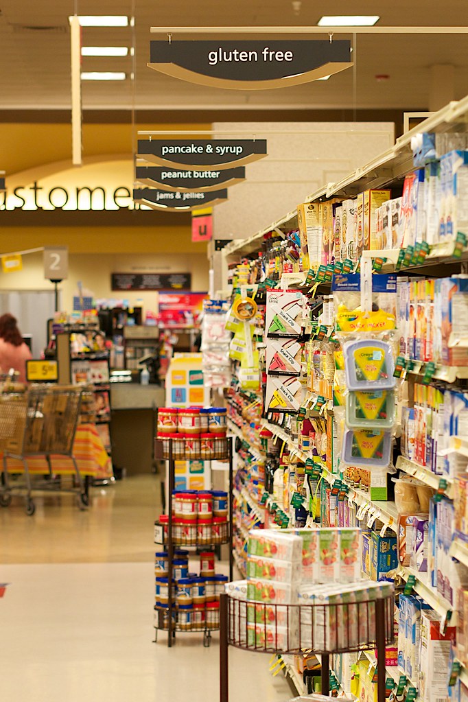 A shopping cart filled with bulk items in a warehouse club store aisle (warehouse club membership)